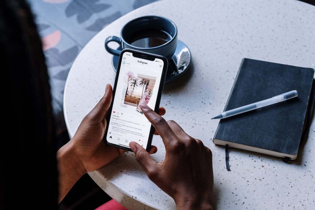 Woman holding phone looking at Instagram