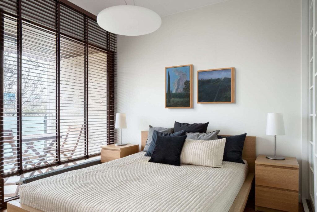 Two framed landscape paintings hung side by side above a bed in a room mockup preview.